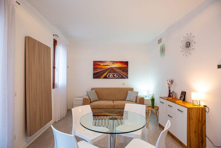 Apartment dining and living area with a glass table and sofa