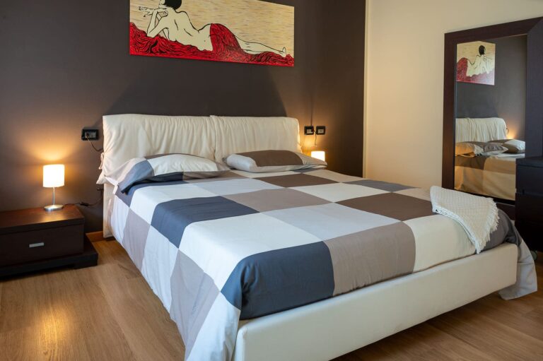 Double bedroom with bedside lamps and a full-length mirror